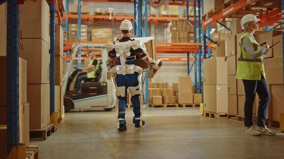高科技未来仓库:工人穿着先进的全身动力外骨骼举起和行走与沉重的托盘装满纸板箱Exosuit增强了人类的表现和力量
