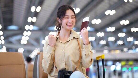 亚洲妇女在机场等待离开假期假期肖像微笑的亚洲年轻女子看着相机面部表情高兴
