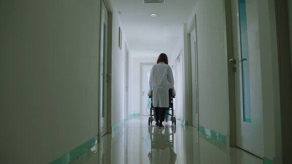 一位亚洲女医生正在医院走廊里推着轮椅向病人们走来