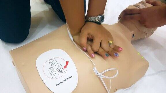 学生在心肺复苏训练班学习如何使用心肺复苏娃娃和AED机抢救紧急情况下的病人