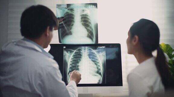 亚洲医生拿着x光片向病人解释结果