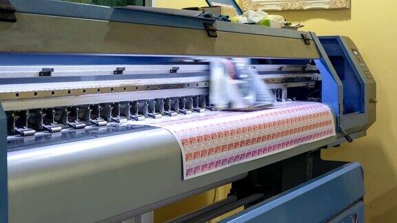 大型喷墨打印机与品牌和技术人员工作在不干胶单