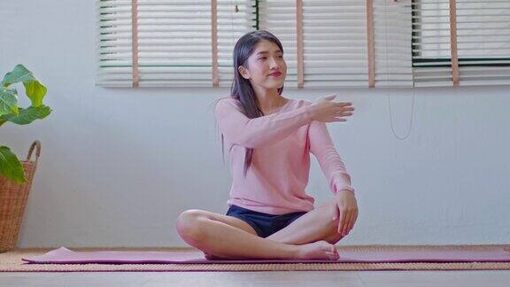 平静的亚洲女性在休闲伸展肌肉热身呼吸和冥想与瑜伽在家健康的女性做瑜伽感觉如此舒适和放松健康瑜伽保健概念