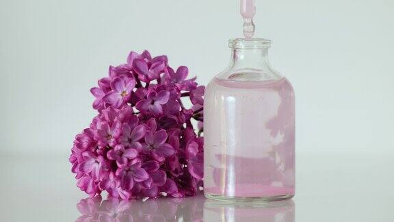 丁香精油带有紫丁香香味的花香香水香水在实验室生产香水一滴精油从化妆品吸管中缓缓滴入香水中