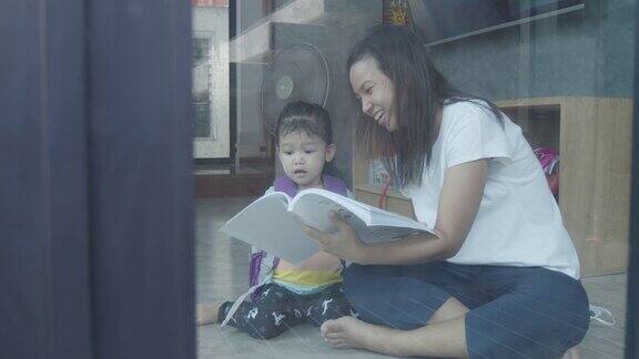 亚裔年轻母亲和女儿在家阅读慢动作