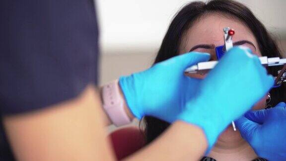牙医在医疗手套使用特殊工具检查病人在牙科诊所