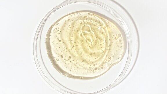 透明的黄色化妆品凝胶液泡沫在一个玻璃碗的皮氏MacroShot精华液乳霜透明尿酸有机化妆品、药品皮肤护理概念