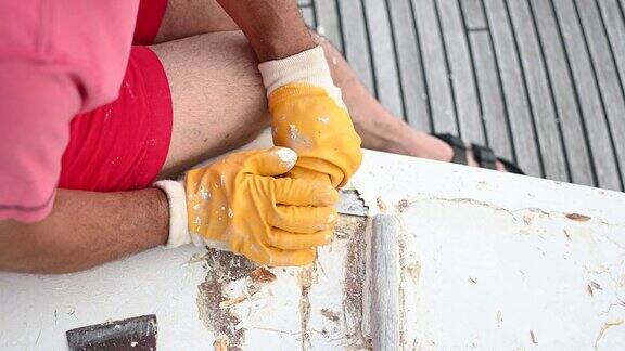 工人用抹刀修理小船