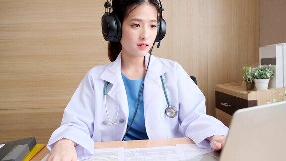 年轻貌美的亚洲女医生在视频会议中看着镜头边说话边诊断积极的医生在平板电脑上挥手边在线咨询