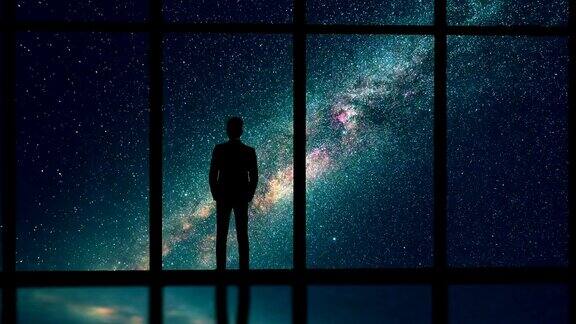 在星空的背景下站在窗边的男性时间流逝