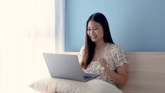 4K50fps美丽的亚洲女孩穿着白色花衬衫在他的卧室里与朋友视频聊天问候和愉快地聊天