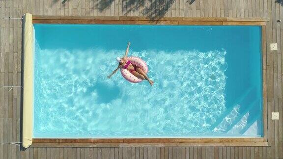 从上到下:快乐的女人在后院的游泳池里享受日光浴