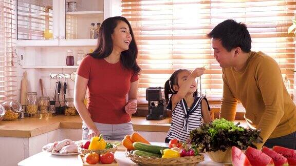 快乐的年轻亚洲家庭准备和烹饪健康的食物在厨房家庭放松和花时间在一起在家里
