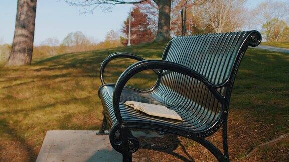 在空旷的公园长椅上打开一本书风吹过书页