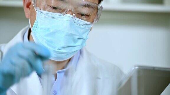 在实验室工作的亚洲男性科学家疫苗研发