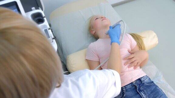 医生正在用超声波扫描仪检查患者女童甲状腺