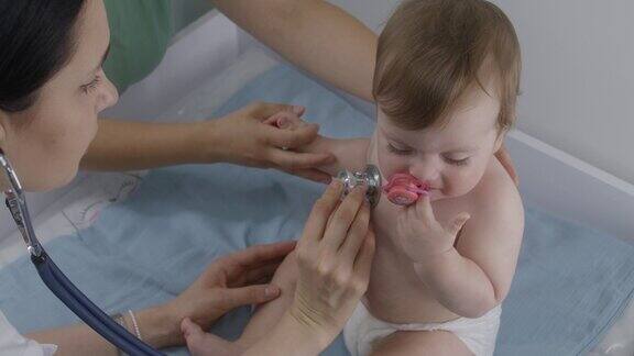 医生用听诊器听婴儿的肺