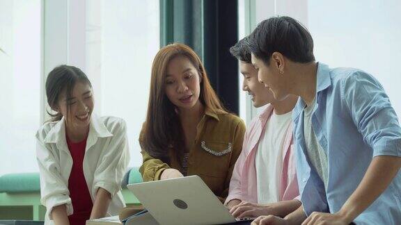 一群快乐的亚洲青年大学生用笔记本电脑进行头脑风暴和讨论通过网络和教科书在高校图书馆科技学科中查找信息有趣的