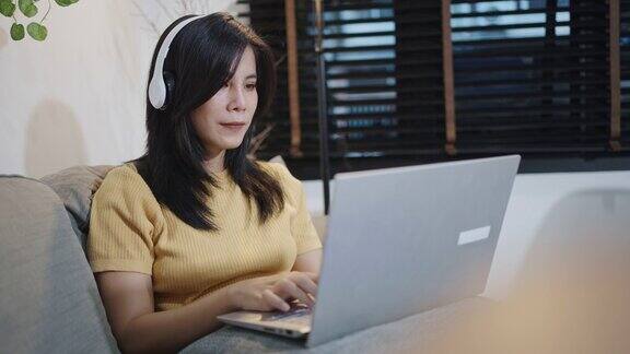 视频肖像的年轻成年亚洲女性自由职业者使用笔记本电脑在线工作在家女性与同事进行视频会议而远程工作在家里