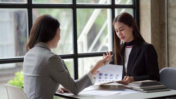 亚洲女领导在会议上用电脑教学指导业务团队女高管解释在线项目谈话帮助年轻同事在办公室咨询客户