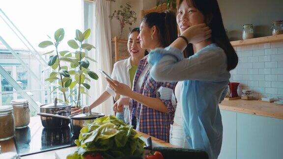 三个快乐的年轻女子在厨房准备亚洲食物