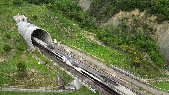 一列高速客运列车进入山脚下隧道的无人机全景图俯瞰法国南部的群山