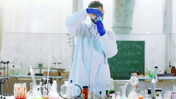 医药学生在化学实验室使用一些实验室的浴盆蓝色液体来测试化学反应