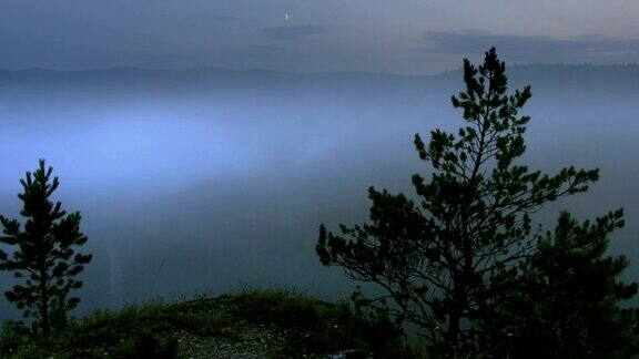 从高地上看夜间森林上空升起的延时雾