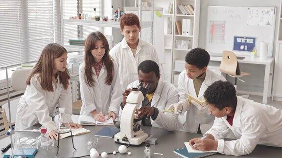 教师在科学课上使用显微镜