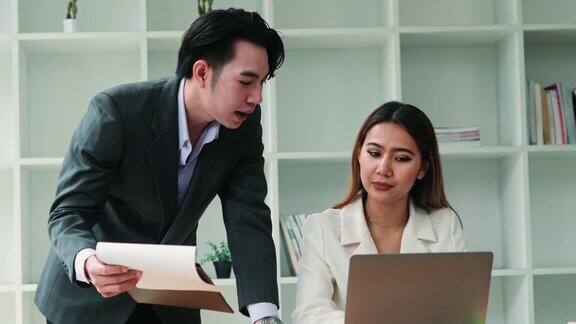 年轻的亚洲客户经理顾问向客户合作伙伴展示纸质文件不同的专业同事在会议上讨论办公室工作的税务金融合同文件