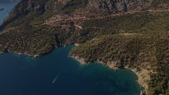 无人机近距离观察清澈的蓝色海水和停泊的船只和游艇停泊在土耳其旅游目的地的海湾