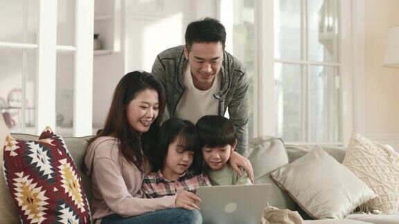 亚洲夫妇和孩子在家里一起使用笔记本电脑