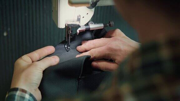 一位男裁缝在私人作坊里摆弄缝纫机