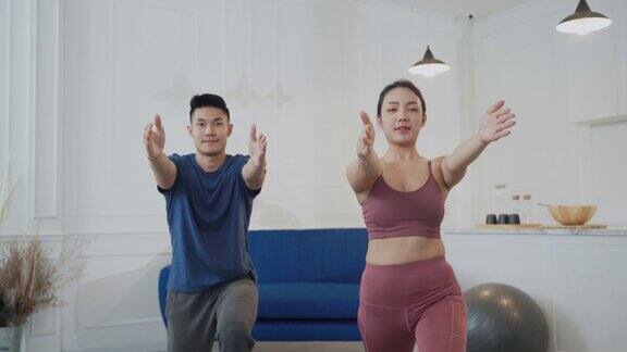 年轻的亚洲夫妇在家里一起练瑜伽