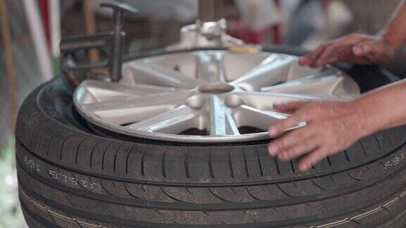 机械师有修理汽车的专业知识和技能工作是在车库里给合金车轮装新轮胎汽车维修及服务工人用专用机器在轮辋上安装轮胎轮胎更换概念