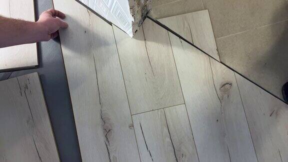 修复地板和人一个人安装木地板的特写