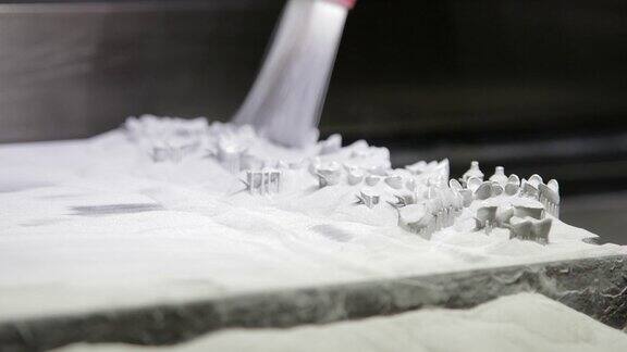 牙科技师在3D中用植牙刷去铸板上的金属粉末