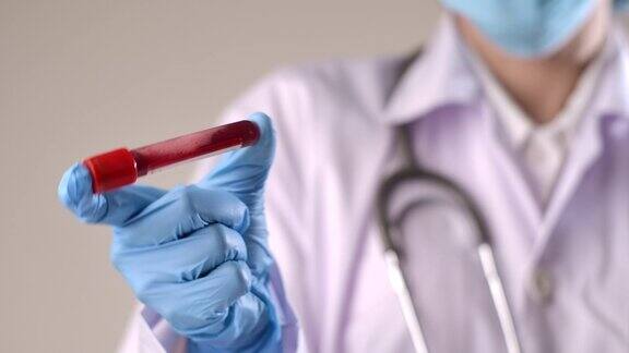 特写医生的手搅拌血液管用于测试