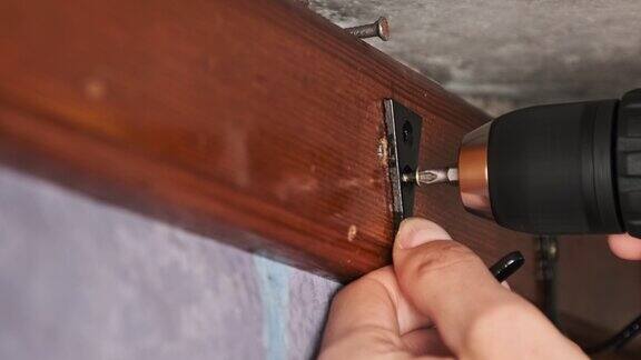 工匠用电动螺丝刀将自攻螺钉拧入单板
