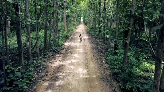 美丽的亚洲女孩喜欢在泰国乡村的森林里骑自行车旅行