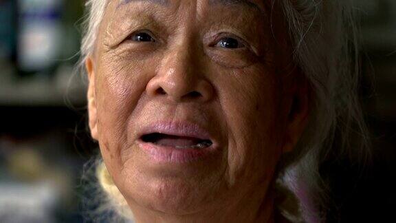 年长的亚洲女人吃饭的肖像