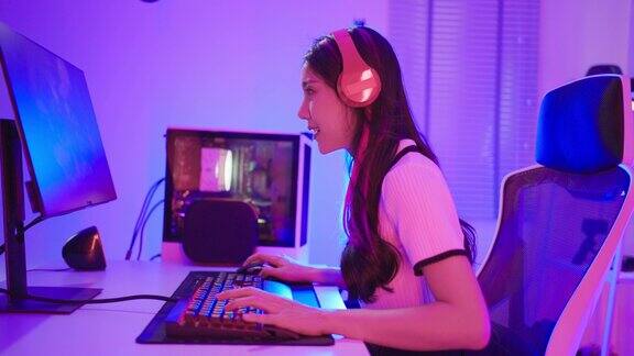 亚洲美丽的电子竞技女玩家在电脑上玩在线视频游戏有吸引力的年轻女孩游戏玩家感到快乐享受技术直播而在家里玩网络比赛
