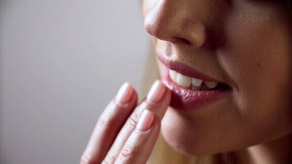 唇护理女人用手指触摸柔软的嘴唇特写