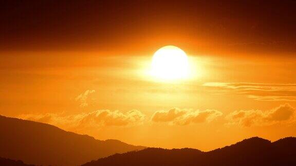橘红色的太阳从云层中钻出来向地平线移动