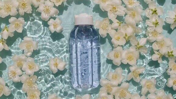 茉莉花的花瓣在水面上有水滴化妆品瓶、油瓶、液体、胶原蛋白精华液女性化妆品护肤品布局美容产品样品