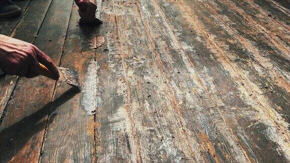 用抹刀将胶水涂在地板上的木地板缝隙上