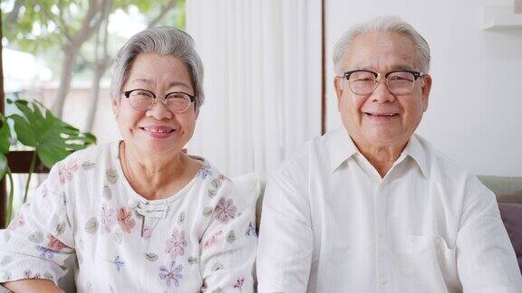描绘快乐的亚洲老年夫妇在家里微笑和大笑