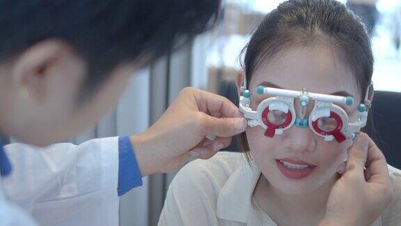 男性验光师使用光学试验架检查女性视力