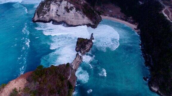 航拍海湾碧蓝的海水岩石峭壁和海浪碰撞