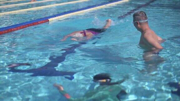 亚洲中国年长妇女学习游泳指导教练在游泳池和她的退休社区在周末上午